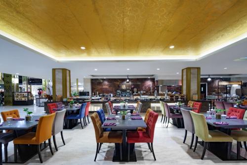 a dining room with tables and chairs and a restaurant at Swiss-Belhotel Makassar in Makassar