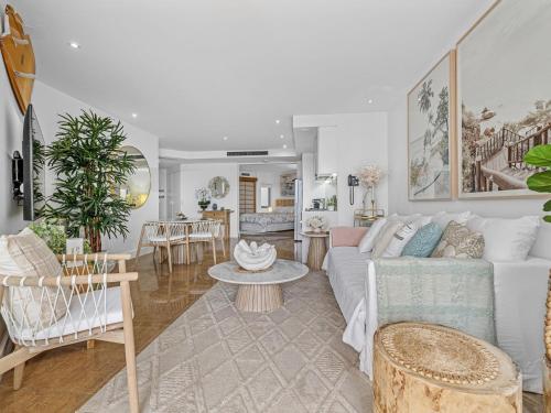 a living room with a white couch and chairs at Cotton Beach 21 - Coastal Elegance with pool in Casuarina