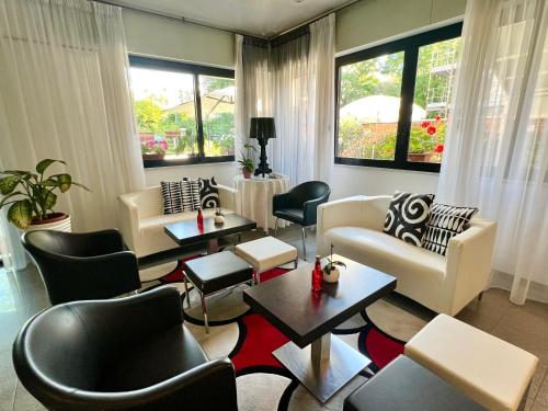 un soggiorno con divani, tavoli e sedie di Hotel Betty a Rimini