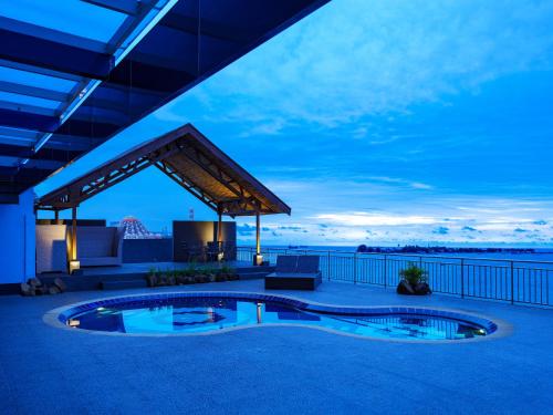 a patio with a swimming pool at night at Swiss-Belhotel Makassar in Makassar