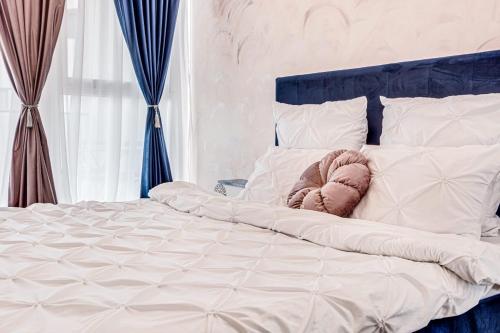 uma cama branca com uma cabeceira e almofadas azuis em ARI Rose Apartment in complexul Ared Kaufland em Arad