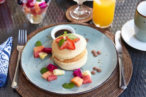 a plate with a cake and fruit on a table at Temple Hill Residence Villa in Jimbaran