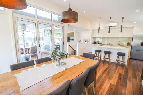 a kitchen and dining room with a wooden table and chairs at Villa Urbane in Bright
