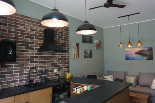 a kitchen with a brick wall and pendant lights at Casa Bonita 2 Bedroom apt with the Best view in Town! in Paleros