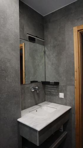 a bathroom with a white sink and a mirror at Casa Bonita 2 Bedroom apt with the Best view in Town! in Paleros