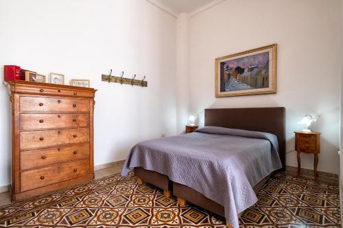 a bedroom with a bed and a dresser at Il Conte e La Contessa in Sennori