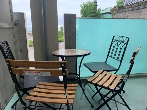 two chairs and a table and a chair on a balcony at O2 capsule house OTARU in Otaru