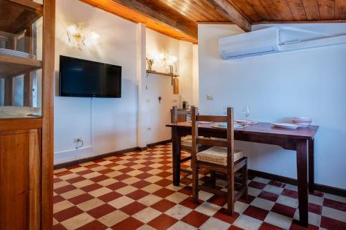 a dining room with a table and a tv on the wall at Il Conte e La Contessa in Sennori