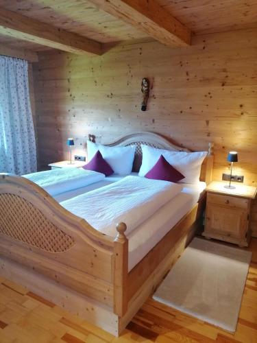 a bedroom with a large bed in a log cabin at Riedhof in Brandenberg
