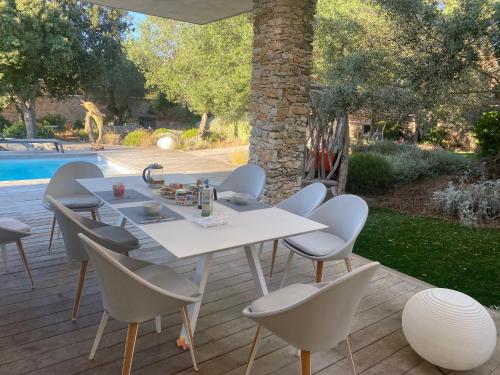 d'une terrasse avec une table et des chaises blanches à côté de la piscine. dans l'établissement Casa Felicia, à Bonifacio