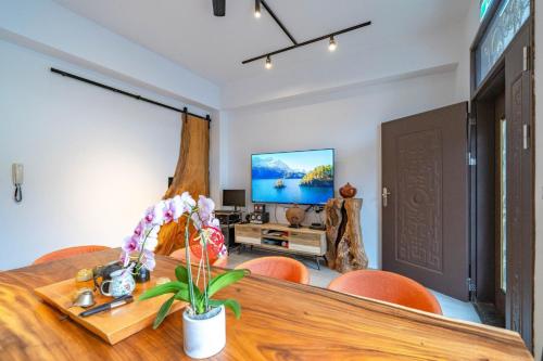a dining room with a table and chairs and a tv at Tianshe Xiangsui B&B in Hualien City