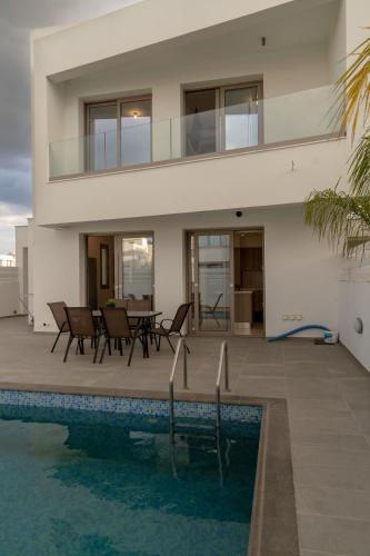 a house with a swimming pool next to a house at Hubstay - Seaview Villa Oriana in Larnaca, 10 min Walk to the Beach in Larnaka