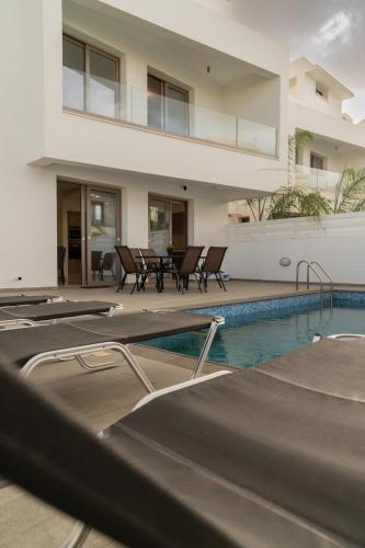 a villa with a swimming pool and a house at Hubstay - Seaview Villa Oriana in Larnaca, 10 min Walk to the Beach in Larnaka