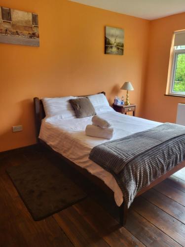 a bedroom with a bed with two towels on it at The Barn Lodge in Tullamore