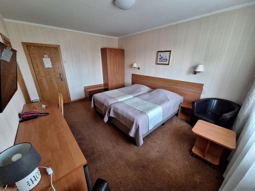 um quarto com uma cama, uma secretária e uma cadeira em Home B&B em Kaunas