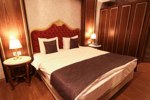 a bedroom with a large bed with a red headboard at Vivaldi Park Hotel in Ankara