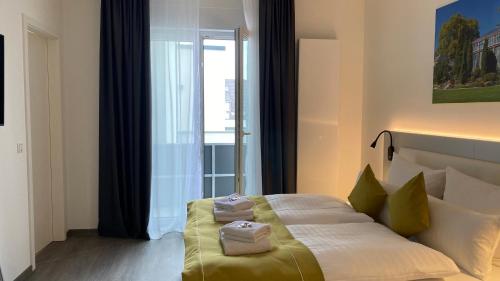 a bedroom with a bed with two towels on it at GuestHouse Große Linde in Karlsruhe