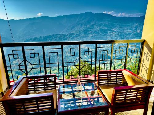 d'un balcon avec deux chaises et une table en verre. dans l'établissement Staynest Tara with mountain valley view near MALL ROAD, à Gangtok
