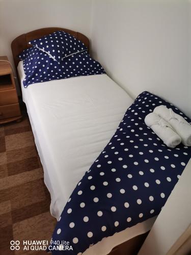 a small bed with polka dot sheets on it at Kokó Panzió in Harkány