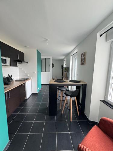 une cuisine avec une table et des chaises dans une pièce dans l'établissement Appartement avec terrasse privée, à Chaumont