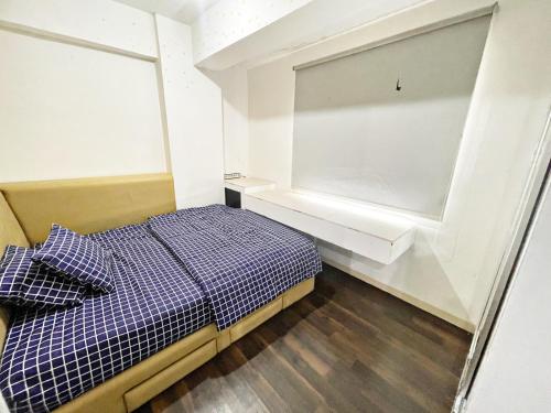 Cozy 2BR Apt with direct access to Mall @Green Bay Pluit Apartment في جاكرتا: غرفة نوم صغيرة بها سرير ونافذة