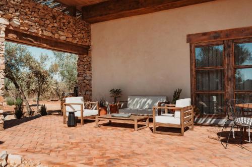 a patio with chairs and a couch and a table at Hábimo - Valle de Guadalupe in Valle de Guadalupe