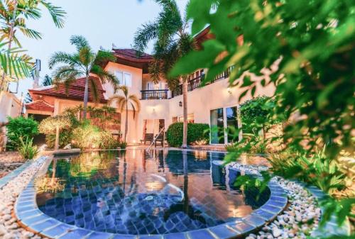 a house with a swimming pool in front of a house at Luxury Garden Pool Villa near Beach & Walking Street in Pattaya South