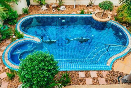 an overhead view of a swimming pool with dolphins in it at Luxury Garden Pool Villa near Beach & Walking Street in Pattaya South