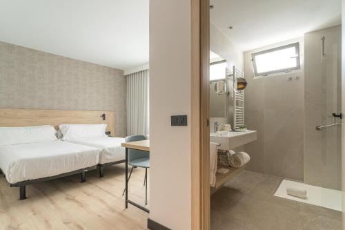パンプローナにあるホテル ブランカ デ ナヴァラのベッドとバスルーム付きのホテルルームです。