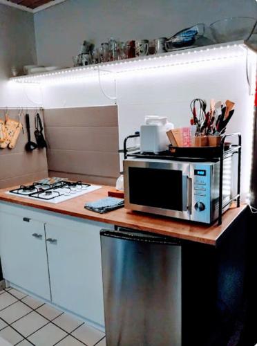une cuisine avec un four micro-ondes au-dessus d'un comptoir dans l'établissement Maison de village appartement RDC avec terrasse, à Gy