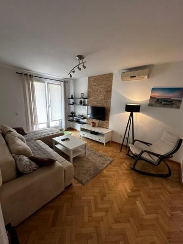 a living room with a couch and a chair at City apartment with the sea view in Bar