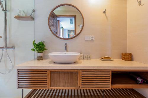 a bathroom with a sink and a mirror at Bonny Boutique Hotel Da Nang in Da Nang