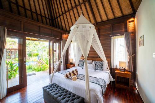 a bedroom with a bed with a canopy at D'Puncak Villas Lembongan in Nusa Lembongan