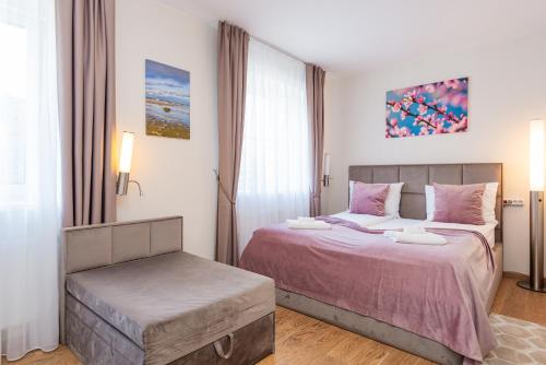 a bedroom with two beds and a ottoman at 1912 Bed & Breakfast in Klaipėda