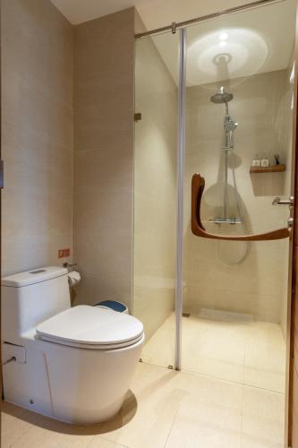 a bathroom with a toilet and a glass shower at Bonny Boutique Hotel Da Nang in Da Nang
