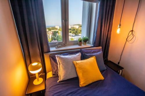 sypialnia z łóżkiem z poduszkami i oknem w obiekcie Krasickiego 14 w mieście Gdynia