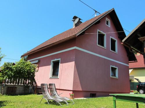 uma casa cor-de-rosa com um gato por cima. em Modern apartment with garden near the Petzen ski area in Eberndorf Carinthia em Eberndorf