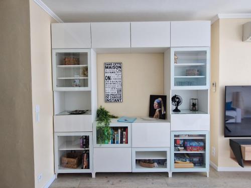 a white book shelf in a living room at La PerleCanet - vue mer au centre in Canet-en-Roussillon