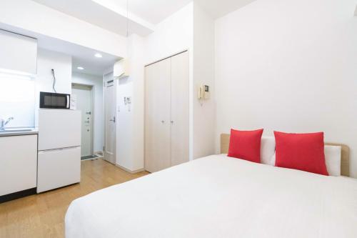 a bedroom with a white bed and red pillows at Ihatov Komazawa in Tokyo