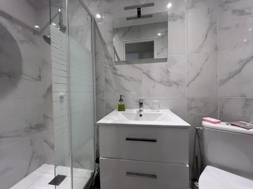 une salle de bain blanche avec un lavabo et une douche dans l'établissement Proche promenade des Anglais, à Nice
