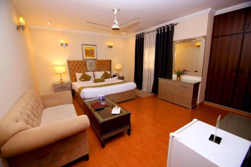 a hotel room with a bed and a living room at Premier Inn Grand Gulberg Lahore in Lahore