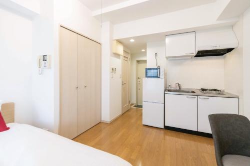 a white kitchen with a sink and a refrigerator at Ihatov Komazawa in Tokyo