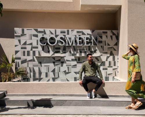 a man and a woman sitting on the steps of a building at Cosmeen Lifestyle Boutique Stay in Hersonissos