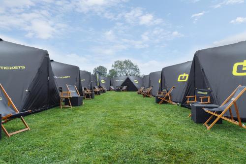 een rij zwarte tenten op het gras bij Global-Tickets Village Spa-Francorchamps in Francorchamps