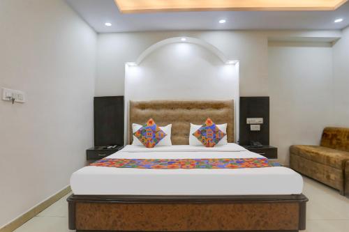 a bedroom with a large bed with a headboard at FabHotel Classic in Bhopal