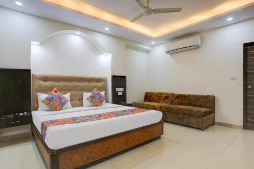 a bedroom with a large bed and a couch at FabHotel Classic in Bhopal