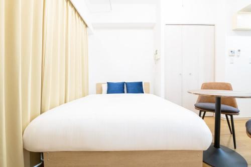 a bedroom with a bed and a table and a chair at Ihatov Komazawa in Tokyo