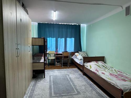 a bedroom with two bunk beds and a dining room at Student Castle Almaty hostel in Almaty