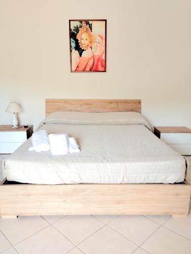 a bedroom with a bed with a wooden frame at B&B Damiani in Santa Maria di Castellabate
