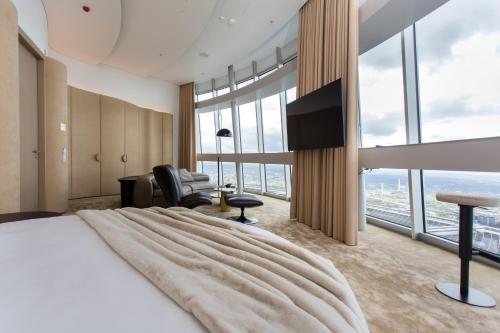 a hotel room with a large bed with a large window at Vilnius TV Tower Apartments DEBESYS in Vilnius
